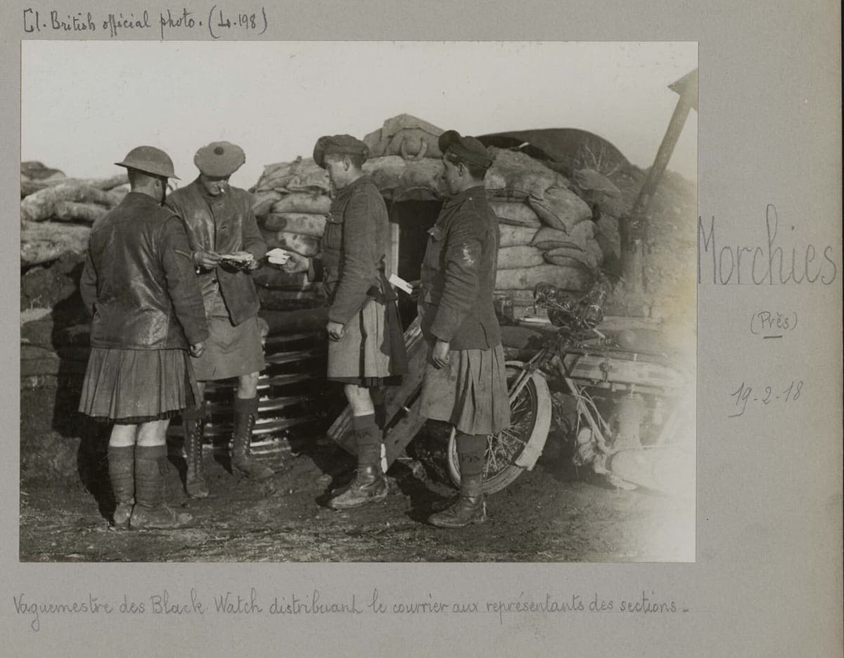 Photographie officielle britannique : un vaguemestre du Black Watch distribue le courrier devant un abri de sacs de sable, près de Morchies