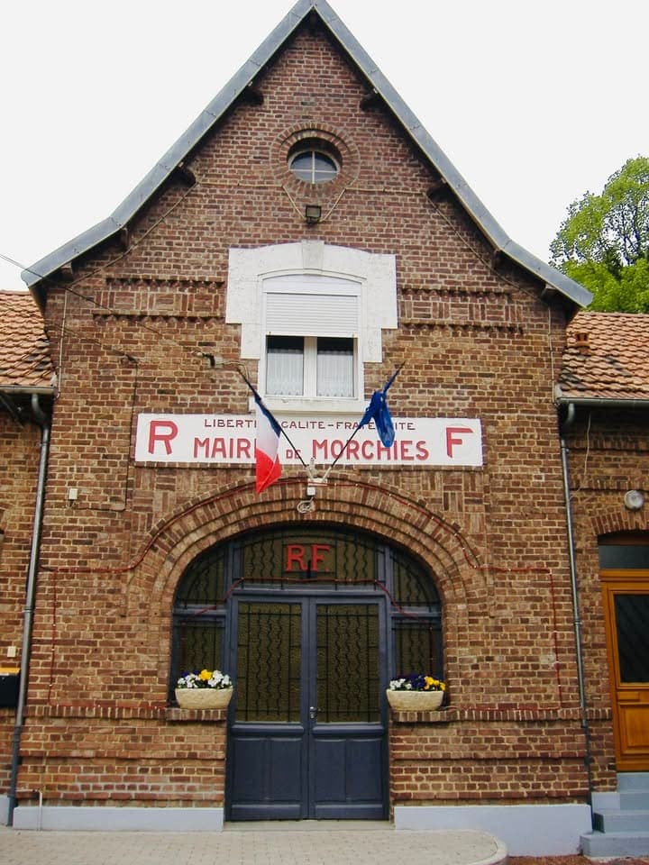 La façade en brique de la mairie de Morchies, pavoisée, avec l’inscription « Mairie de Morchies »